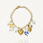 Vue d'ensemble bracelet chaîne acier inoxydable doré avec multiples pendentifs cœurs et perles bleues.