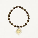 Bracelet fin perles Marrons avec pendentif cœur sacré doré sur fond blanc.