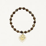 Bracelet fin perles Marrons avec pendentif cœur sacré doré sur fond blanc.