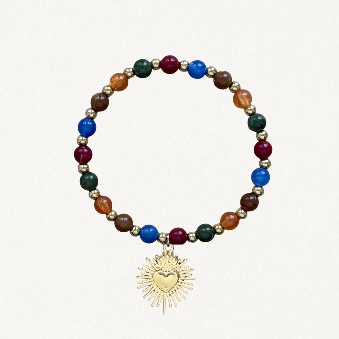 Bracelet fin perles Multicolores avec pendentif cœur sacré doré sur fond blanc.