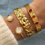 Bracelet jonc Rubia à pierres rouges porté en accumulation (stacking) avec la manchette large martelée Anouchka.