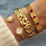 Bracelet jonc Rubia à pierres rouges porté en accumulation (stacking) avec la manchette large martelée Anouchka.