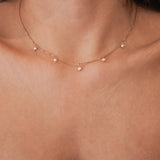 Vue d'ensemble du collier fin doré à petites perles espacées, bijou délicat et féminin.