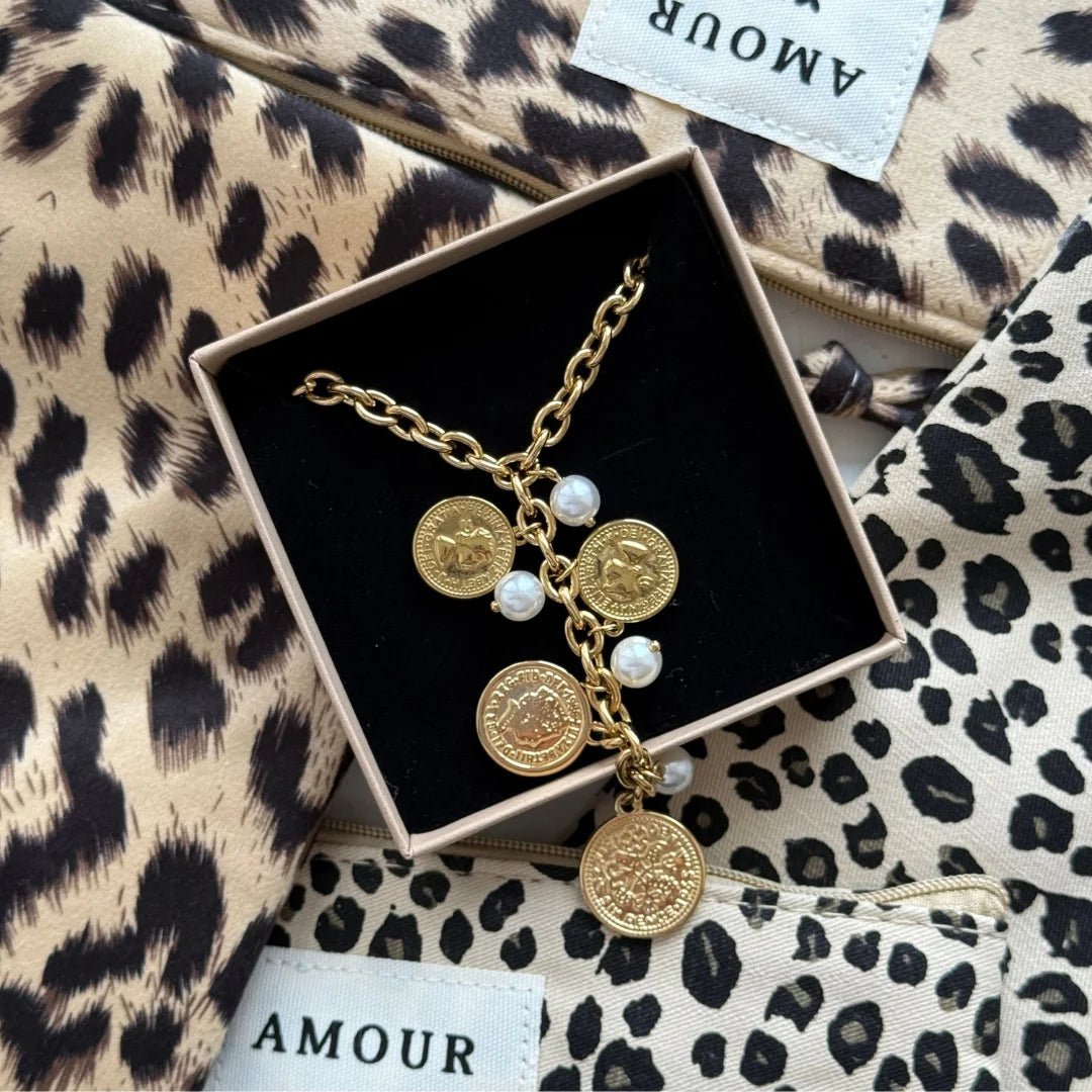 Collier à pampilles pièces et perles Axelle présenté dans son coffret cadeau Maison de l'Amour sur pochette léopard.