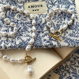 Parure bijoux perles : le collier et le bracelet Edith posés sur leur pochette en tissu à motifs bleus.