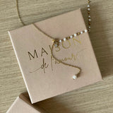 Collier fin style chapelet avec perles et chaîne pendante présenté sur sa boîte cadeau Maison de l'Amour.