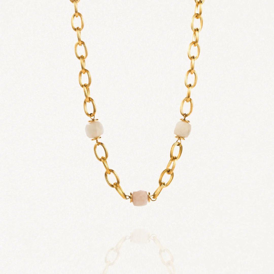 Collier grosse maille acier doré avec perles Blanches sur fond blanc.