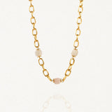 Collier grosse maille acier doré avec perles Blanches sur fond blanc.