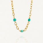 Collier grosse maille acier doré avec perles Turquoises sur fond blanc.