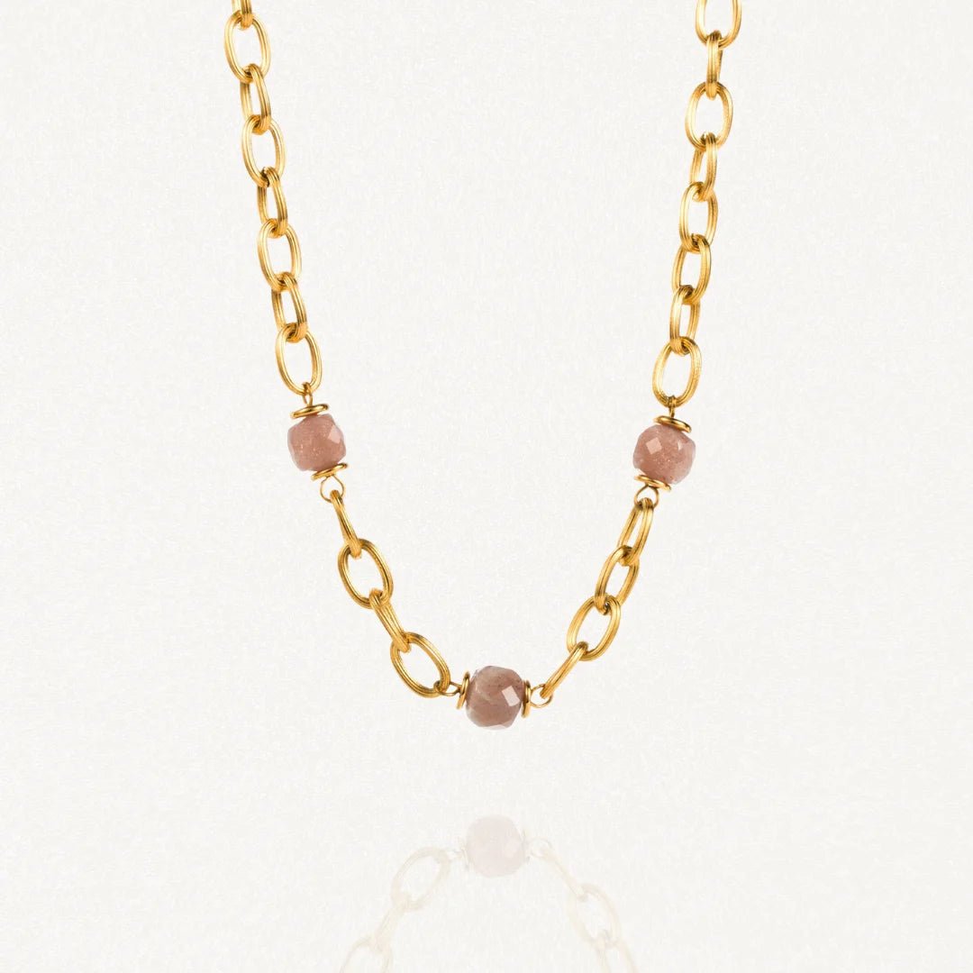 Collier grosse maille acier doré avec perles Roses sur fond blanc.