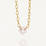 Vue d'ensemble collier grosse maille doré avec pendentif fleur blanche sur fond blanc.