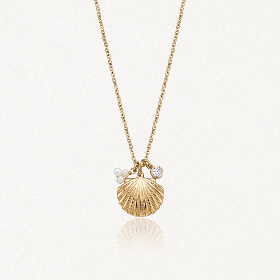Collier en acier inoxydable doré, pendentif coquillage strié, deux petites perles et un cristal rond.