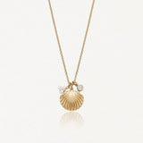 Collier en acier inoxydable doré, pendentif coquillage strié, deux petites perles et un cristal rond.