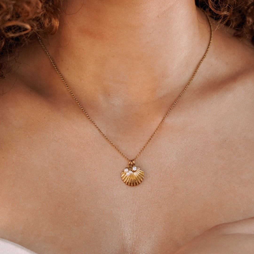 Collier acier inoxydable doré, pendentif coquillage avec 2 perles et un zircon, porté.
