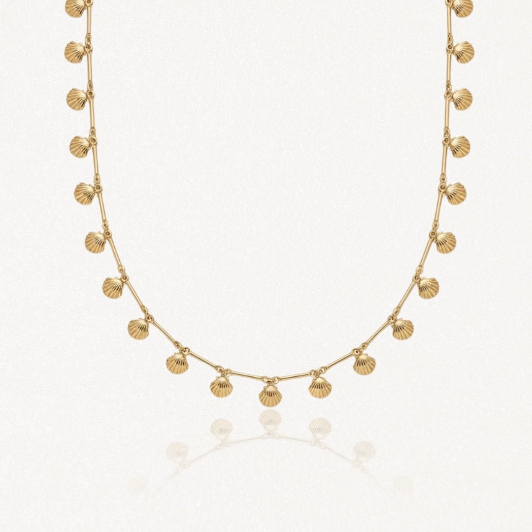 Collier en acier inoxydable doré avec multiples pendentifs coquillages.