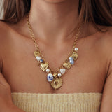 Collier style ex-voto en acier inoxydable doré avec breloques cœurs et perles bleues - Modèle Paula