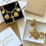 Duo de colliers à charms Zara présentés dans leurs écrins cadeaux Maison de l'Amour.