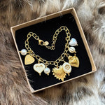 Bracelet à breloques présenté soigneusement dans une boîte cadeau noire et kraft, prêt à offrir.