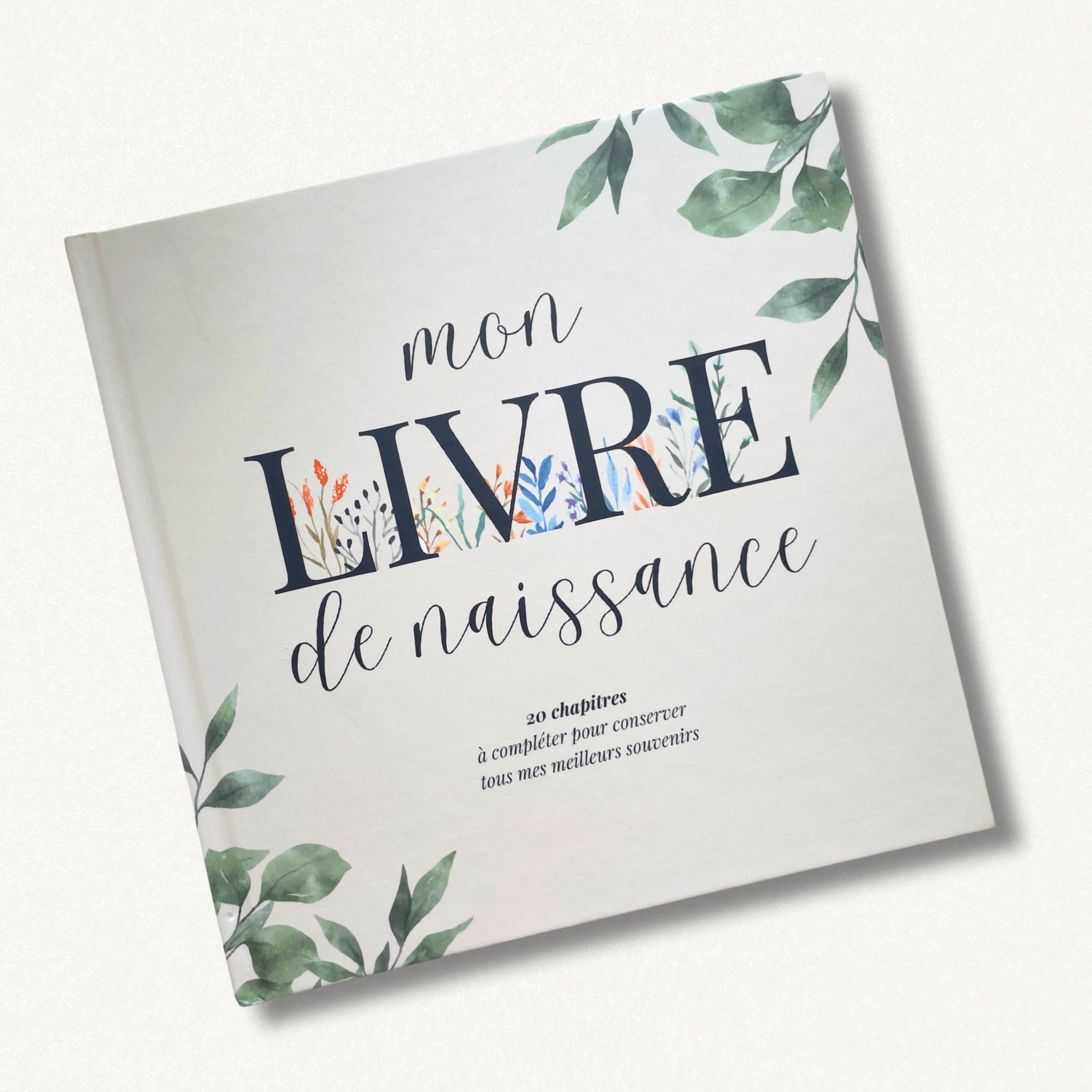 Couverture rigide livre de naissance album bébé souvenirs avec motifs végétaux et titre élégant.