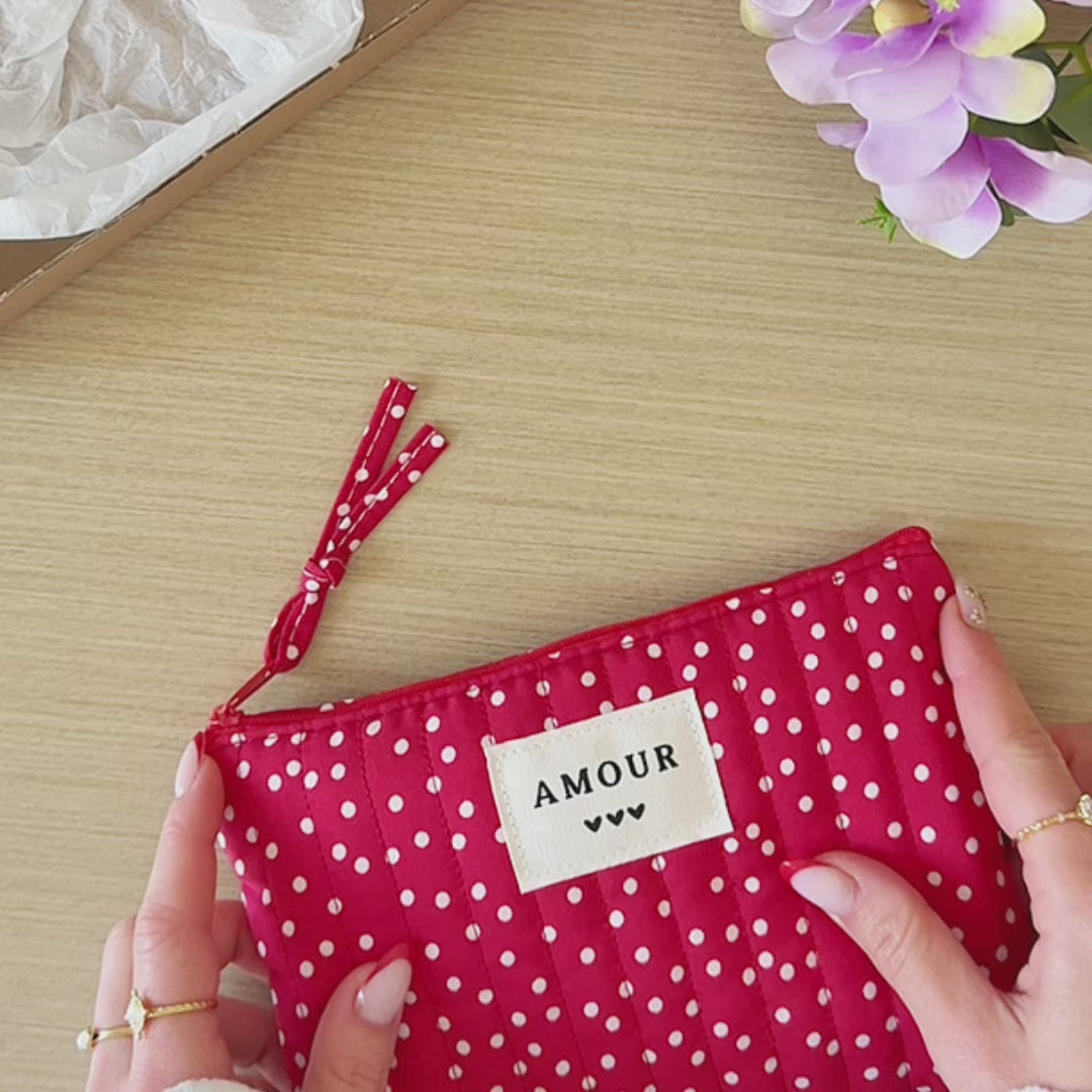 Vidéo duo collier et boucles d'oreilles fleurs dorées présentés avec leur pochette de rangement rouge à pois.