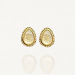 Paires de puces d'oreilles MAISON DE L'AMOUR forme goutte, pierre blanche nacrée effet pierre de lune sertie de doré sur fond blanc.