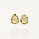 Paires de puces d'oreilles MAISON DE L'AMOUR forme goutte, pierre blanche nacrée effet pierre de lune sertie de doré sur fond blanc.